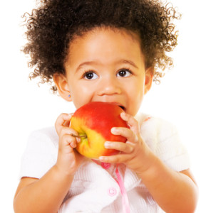 Pretty little girl biting an apple